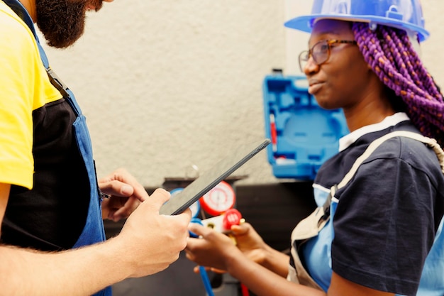 Free photo coworkers refilling hvac system freon