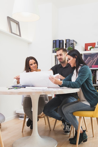 Coworkers sitting with blueprint