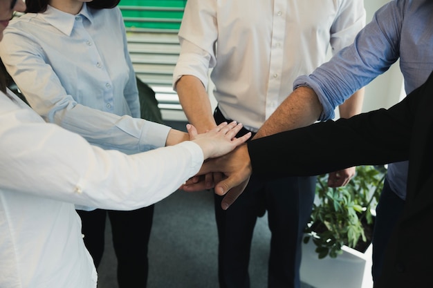 Coworkers stacking hands together