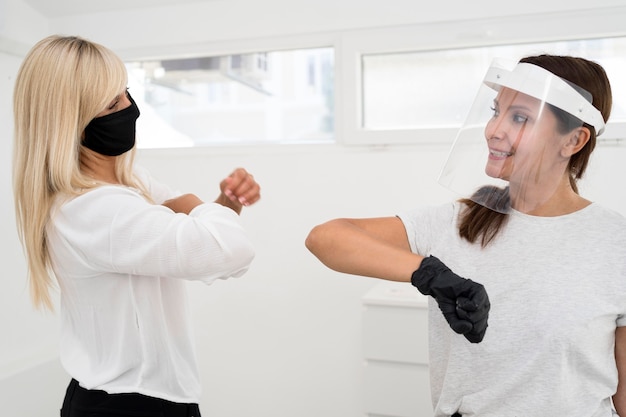 Coworkers using elbow bump alternative greeting front view