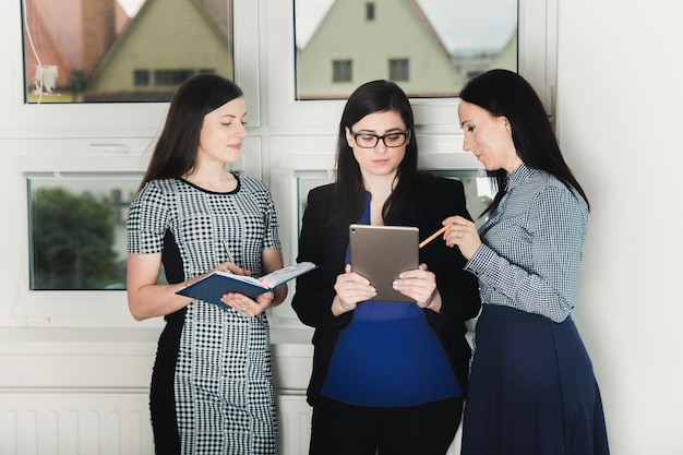 Coworkers with tablet in hall