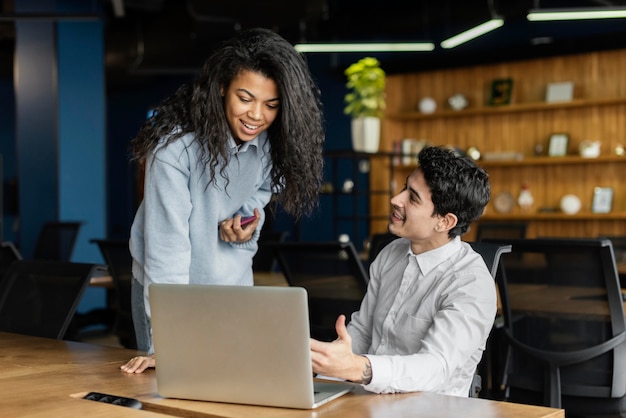 Coworkers working together in the office with laptop