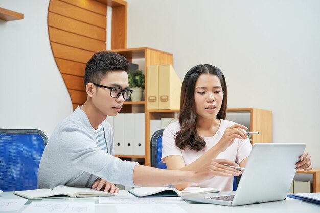 Coworking young businesspeople using laptop