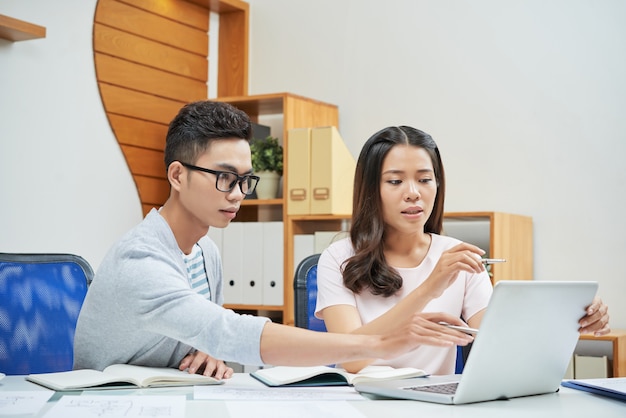 Coworking young businesspeople using laptop