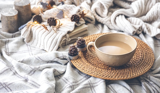 Cozy autumn composition with a big cup of coffee in bed