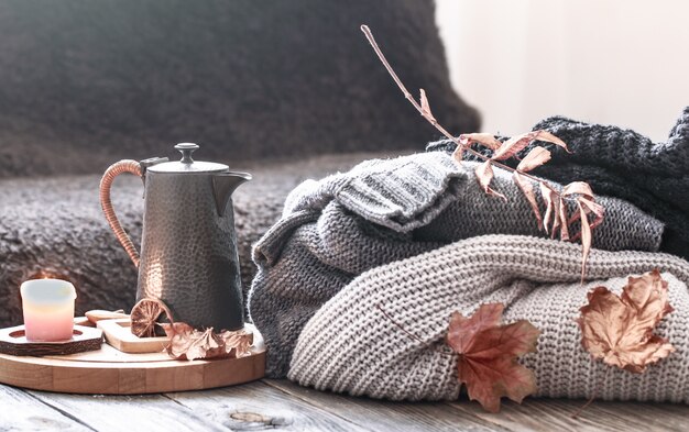 Cozy autumn morning breakfast in bed still life scene. Steaming cup of hot coffee, tea standing near window. Fall.