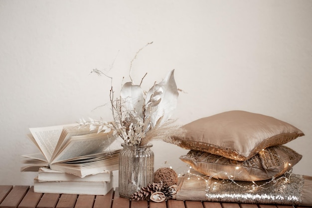 Cozy background with books a vase of dried flowers and decorative cushes