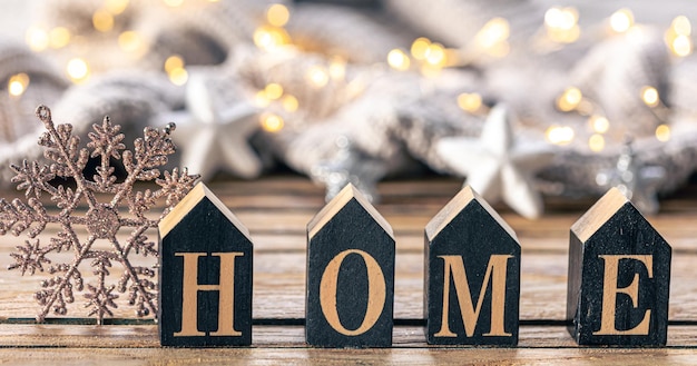 Free photo cozy background with decorative word home on a blurred background with garland