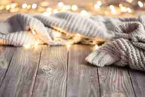 Free photo cozy background with knitted element and bokeh lights on a wooden surface