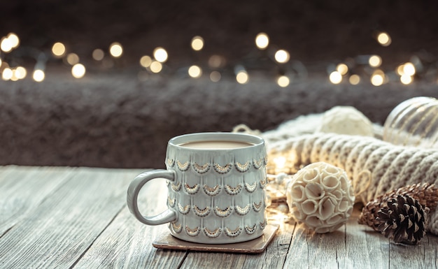 Foto gratuita accogliente sfondo natalizio con una bella tazza e dettagli decorativi su uno sfondo sfocato con bokeh.