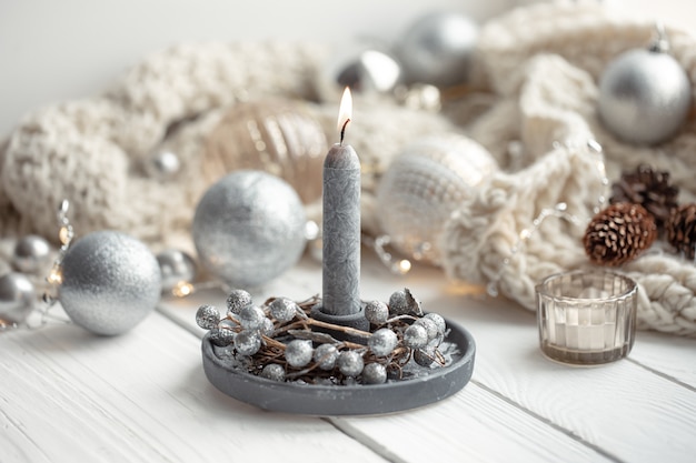 Cozy christmas background with burning candle, christmas balls and decor details.