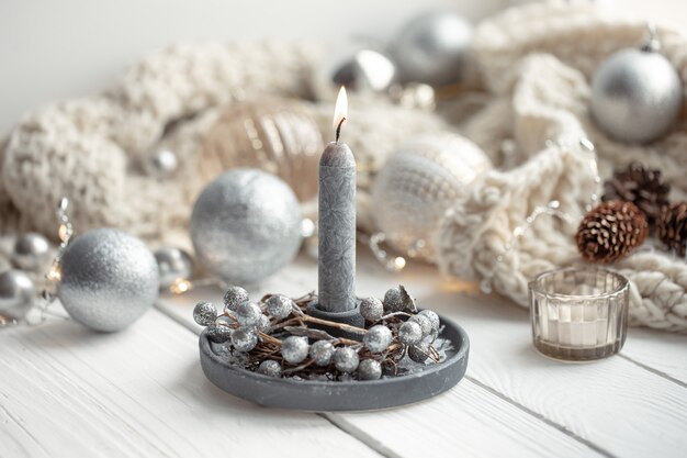 Cozy Christmas background with burning candle, Christmas balls and decor details.