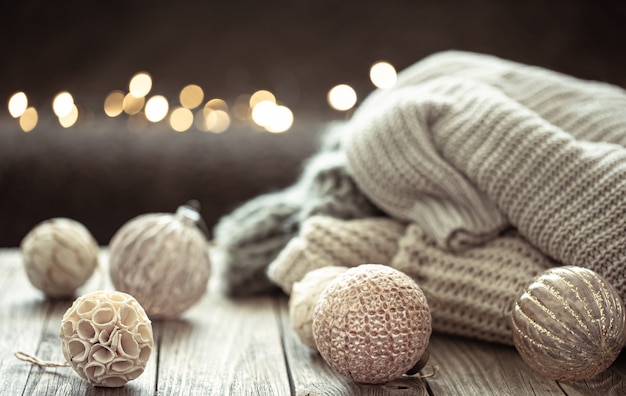 Cozy Christmas background with Christmas decorations and knitted element on a blurred background.