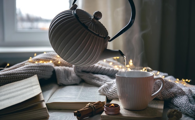 Бесплатное фото Уютная композиция с чайником, чашкой и книгой на размытом фоне