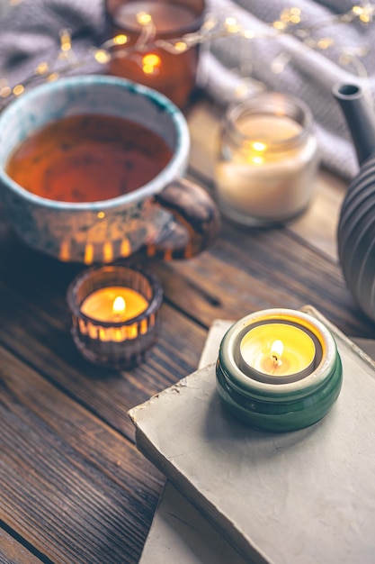 Free photo cozy composition with burning candles books and tea