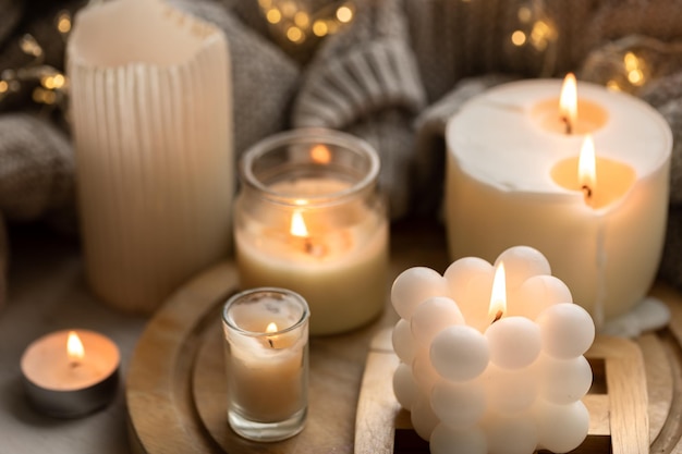 Free photo a cozy composition with candles a knitted element and a garland