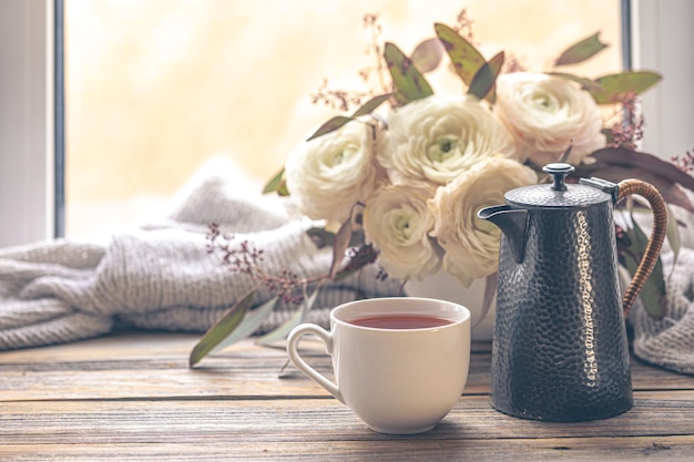 Free photo cozy composition with a cup teapot and flowers