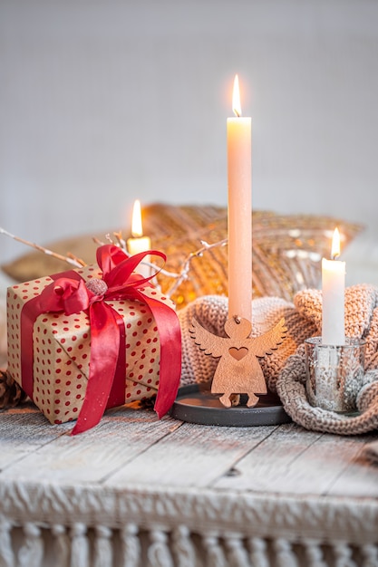 선물과 나무 테이블에 촛불이 있는 아늑한 축제 정물. 축제 개념입니다.