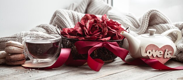 Cozy home composition love is for Valentine's Day with decorative elements and flowers.