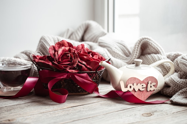 Free photo cozy home composition love is for valentine's day with decorative elements and flowers.