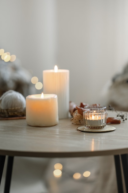 Cozy home composition with candles on blurred bokeh background.