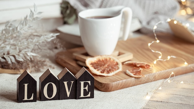 Cozy home composition with decorative word love on blurred space with bokeh.