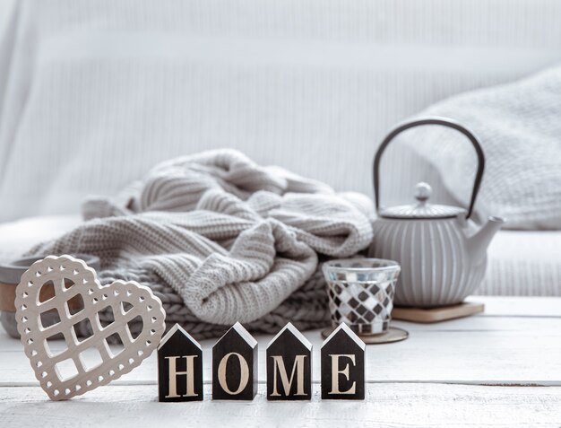 Cozy home composition with a teapot, knitted items and Scandinavian decor details. The concept of home comfort and modern style.