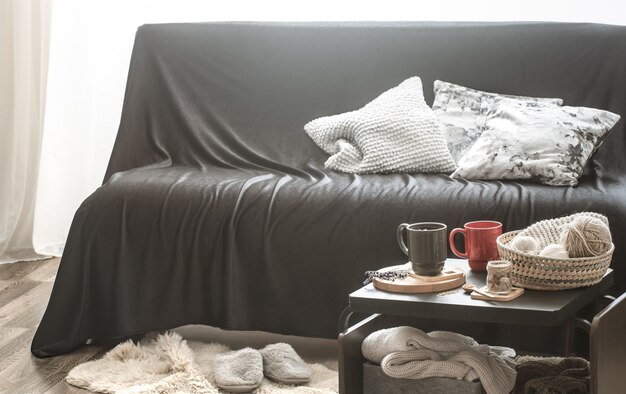 Уютный домашний интерьер гостиной с черным диваном