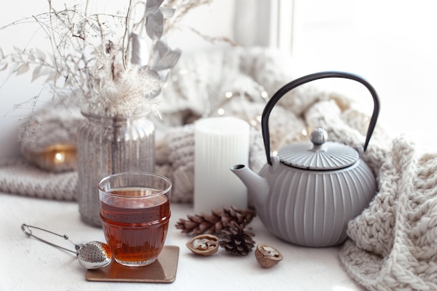 Cozy scandinavian composition with teapot a glass of tea and decor details