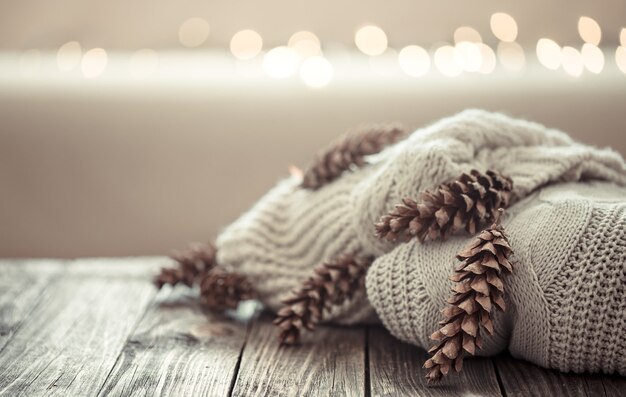 A cozy stack of knitted sweaters with pine cones