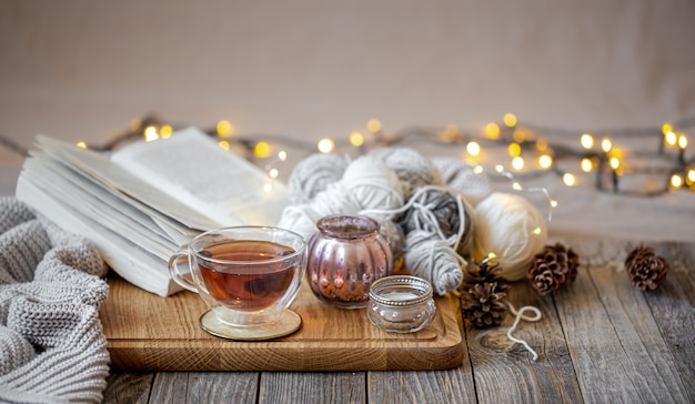 Cozy still life with tea and decorative items, glowing lights in the background.