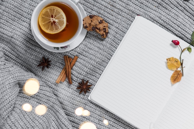 Cozy teatime with notebook on knitted cloth