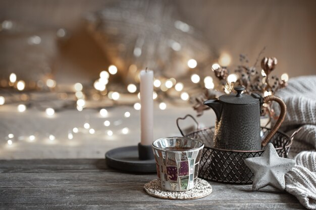 Cozy winter background with details of home decor on a blurred background with lights copy space.