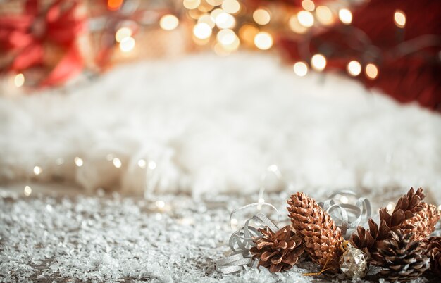 Cozy winter Christmas wall with snow and decorative cones copy space.