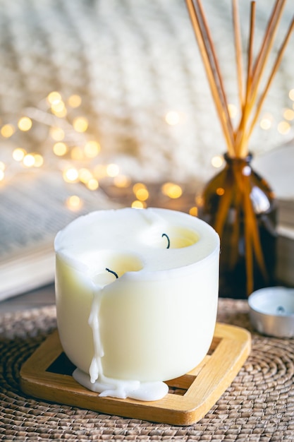 Free photo cozy winter composition with a candle incense sticks and bokeh lights on a blurred background