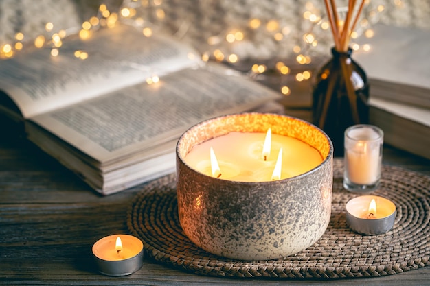 Foto gratuita accogliente composizione invernale con candele su uno sfondo sfocato con libri