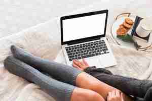 Free photo cozy woman in bed with laptop and snack