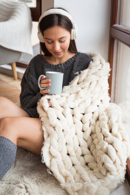 Cozy woman with blanket and mug