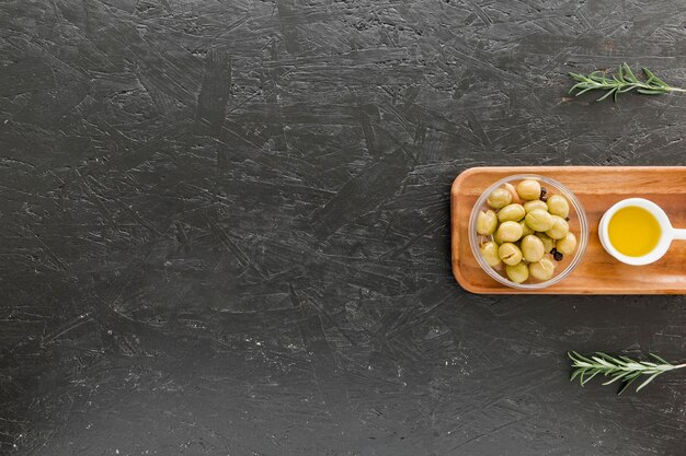 Cozy wooden board with olives and oil 