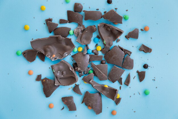 Cracked chocolate with candies on table