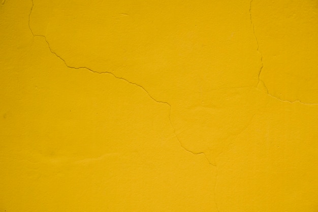 Cracked on the yellow textured wall background