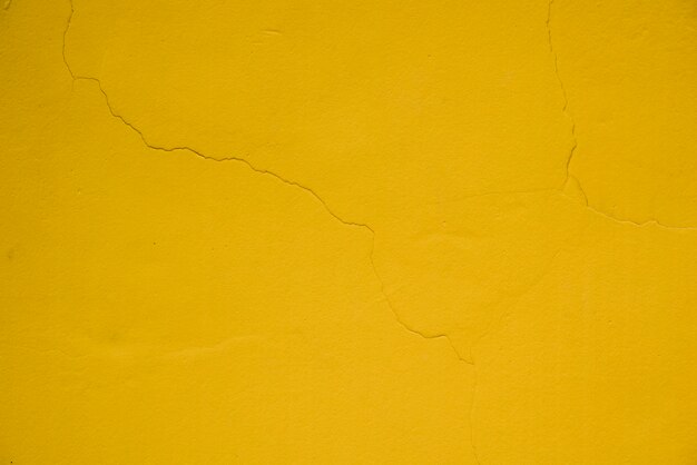 Cracked on the yellow textured wall background