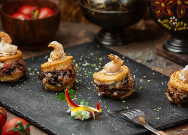 Cracker canapes with stuffing and cream dip sauce.