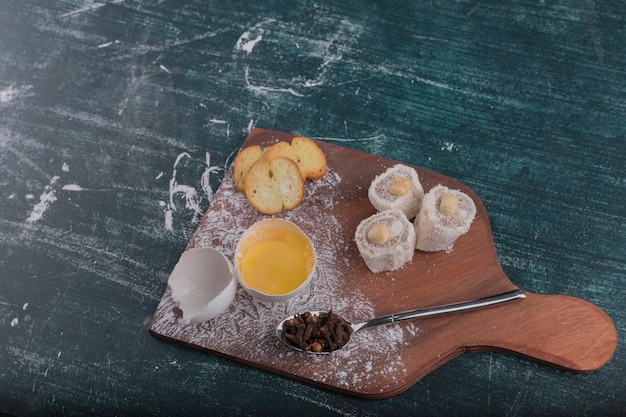 Cracker and delights with an egg yolk on a wooden board