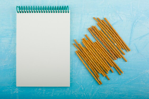 Cracker sticks with a blank receipt book on the blue table