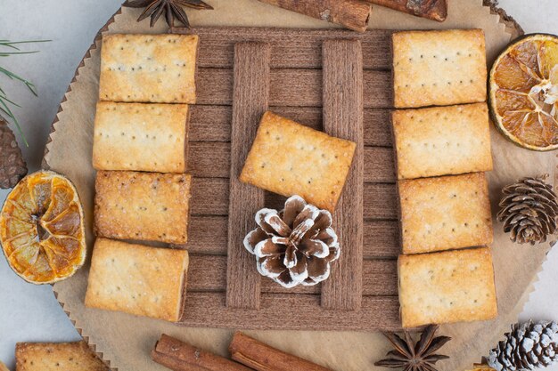 Crackers with aroma cinnamon sticks on wooden plate . High quality photo