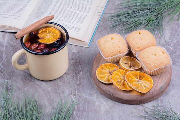 Free photo crackers on a wooden board with lemon slices and a cup of glintwine