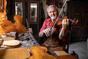 Free photo craftsman checking quality and playing violin in his old-fashion carpenter's workshop