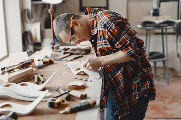 Free photo craftsman cutting a wooden plank