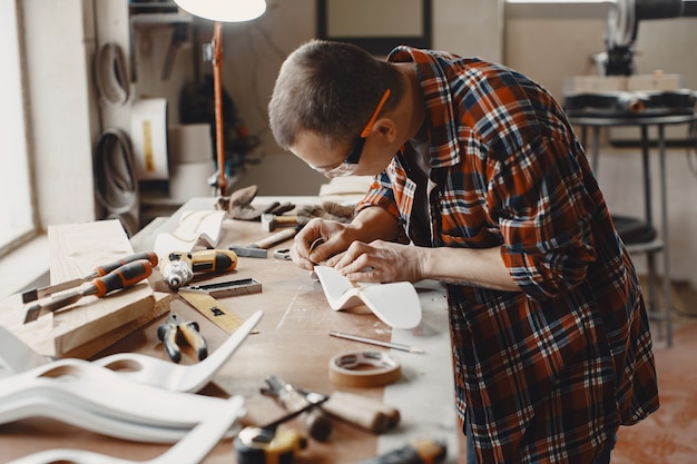 Free photo craftsman cutting a wooden plank